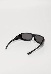Óculos de sol Oakley pretos envolventes com lentes escuras e logótipo dourado na haste, exibidos sobre um fundo branco.