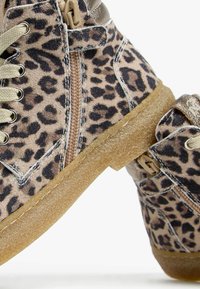 Sneakers alta in tessuto con stampa leopardata, dotate di suola in gomma, chiusura con lacci frontale e cerniera laterale per un facile accesso.