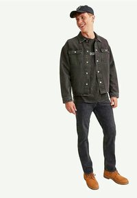 Mustaline teksajakk kahe rinnataskuga, kantud tumeda t-särgi peale. Ühendatud tumedate teksade ja tan värvi töösaabastega, pea peal navy värvi müts.