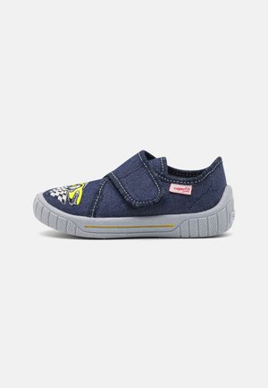 Zapatilla de tela color azul marino para niños, con suela de goma gris, cierre de velcro y bordado de un coche de carreras amarillo y blanco en la puntera.