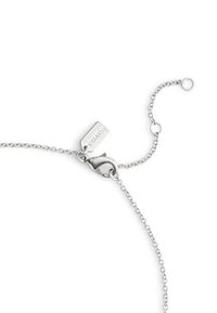 Silver chain bracelet featuring a lobster clasp and adjustable length with a tag reading "COACH." Smooth texture and fine links.