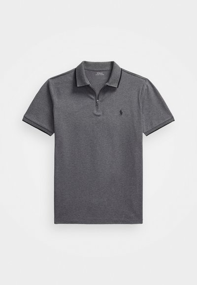 Polo majica v temno sivi barvi z zadrgo pri ovratniku, ki ima teksturirano blago, kratke rokave in majhen črn logotip na levem prsnem delu.