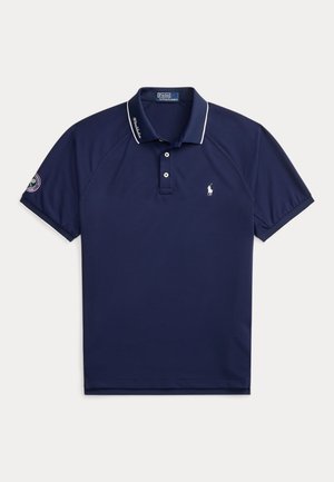 Μπλε ναυτικό κοντομάνικο πόλο Ralph Lauren με λευκή λεπτομέρεια στο γιακά, δύο κουμπιά, λογότυπο στο στήθος και κυκλικό έμβλημα στο αριστερό μανίκι.