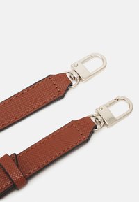 Sangle texturée marron avec des fermoirs en métal argenté, présentant un bord lisse avec un subtil détail de couture contrastante pour plus de durabilité.