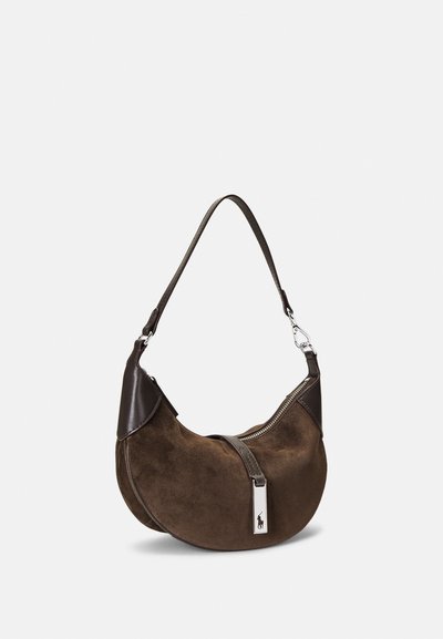 Braune Wildleder-Handtasche mit geschwungenem Design, Lederakzenten, Reißverschluss und silbernem Logodetail. Verfügt über einen einzelnen verstellbaren Schulterriemen.