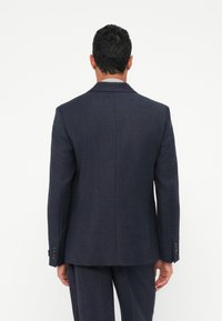 Ναυτικό μπλε σακάκι με απαλό ύφασμα, μία σχισμή στο πίσω μέρος και τέσσερα κουμπιά στα μανίκια. Σχεδιασμένο για εφαρμοστή γραμμή.