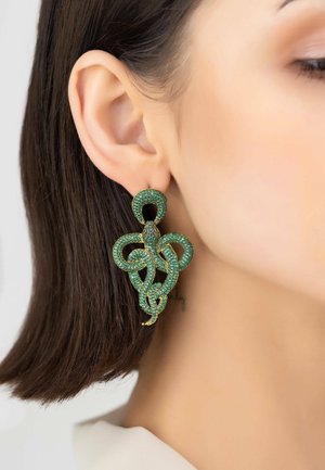 Green snake-shaped earrings with rhinestone embellishments, featuring a gold-tone accent. Large, textured design hangs below the earlobe.