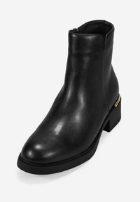 Botín negro de cuero hasta el tobillo con un acabado liso, punta afilada y un tacón bajo de bloque con un acento de color dorado en el costado.