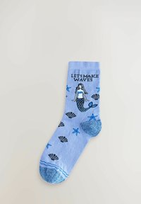 Șosete bleu deschis cu un design de sirenă, accentuate cu scoici și stele de mare. Partea de la vârf este într-o nuanță mai închisă de albastru cu sclipici metalic.