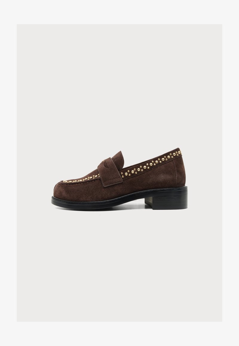 Mocassin en daim marron avec des clous dorés le long des bords, petit talon noir et une bride sur le dessus, présenté de côté sur fond blanc.