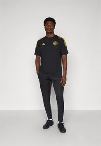 adidas Performance MANCHESTER UNITED 25/26 EUROPEAN COTTON TEE - Article de supporter d'équipe de club - black/tribe yellow