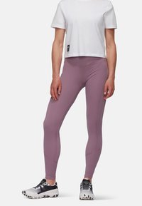 Lys lilla trænings leggings lavet af strækbart materiale med en tætsiddende design. Kombineret med en hvid cropped t-shirt og sorte og hvide sneakers.