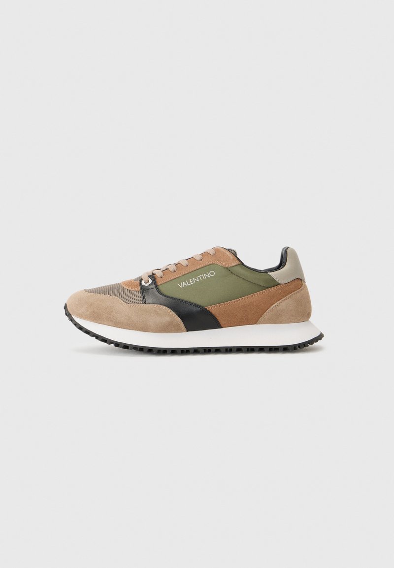 Tan and green suede sneaker featuring mesh accents, black details, and a white sole. Laces and branding visible on the side.