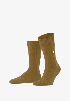Chaussettes brunes à côtes avec une texture tricotée, dotées d'un poignet ajusté et d'un petit accent en métal sur le côté.
