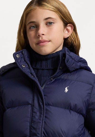 Navy puffer jacket with a hood, featuring a textured knit turtleneck underneath and a small embroidered logo on the chest.