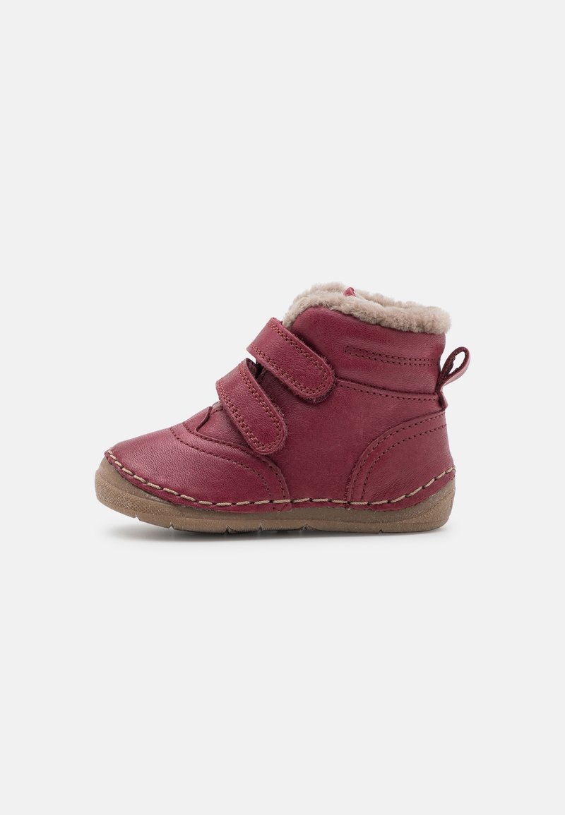 Botte en cuir rouge avec doublure en peluche, deux sangles Velcro et détails cousus. Hauteur courte avec une semelle en caoutchouc pour l'adhérence et le confort.