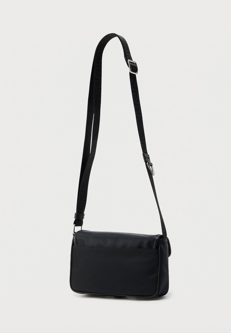 Schwarze Umhängetasche aus glattem Material, rechteckige Form, mit einem gemusterten, verstellbaren Riemen und einem schlanken, minimalistischen Design.