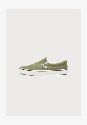 Olivovo zelený slip-on Vans teniska s bielou gumovou podrážkou a čiernym prúžkom, bočnou značkou loga a elastickými bočnými detailmi na svetlom pozadí.