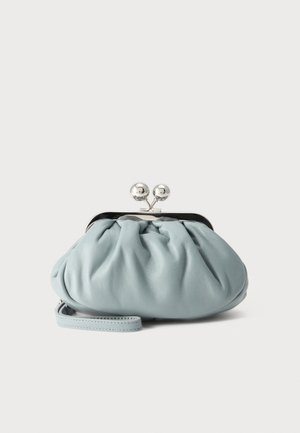 Petit porte-monnaie en cuir bleu doux avec fermoir rond en argent et fine lanière de poignet attachée sur un fond uni.