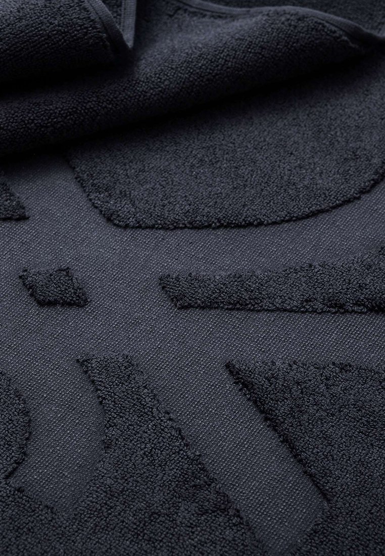 Czarny ręcznik o teksturowanej powierzchni z okrągłym wzorem, wykonany z miękkiego, chłonnego materiału, z detalicznym przeszyciem i gładkimi krawędziami.