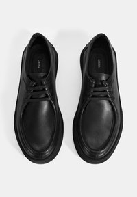 Schwarze Lederschuhe mit runder Zehenform, glatter Oberfläche und passenden Schnüren. Einfaches Design mit einer flachen Gummisohle.