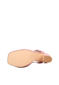 Scarpa con tacco alto rosa, dalla texture liscia, con punta tonda e accentuata da un fiocco. La suola è beige e presenta un motivo leggermente rigato per una migliore aderenza.