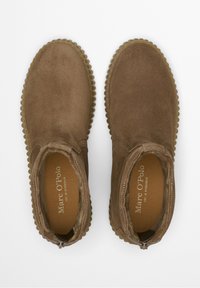 Bruine suède enkellaarzen met een gestructureerde rubberen zool, elastische zijpanelen en een afgeronde neus. De binnenkant is voorzien van een zachte voering.