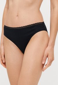 Zwarte katoenen bikini met een geschulpte kantafwerking bij de taille. Het ontwerp heeft een lage taille en een gladde textuur.