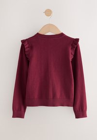 Bordeauxrode trui met lange mouwen en ruches op de schouders, geribbelde manchetten en zoom. Gladde textuur en aansluitende pasvorm.