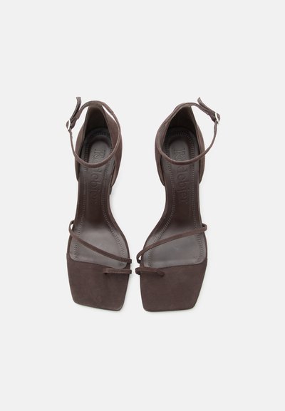 Paire de sandales ouvertes en daim marron avec brides à la cheville et bouts carrés, vue de dessus sur fond blanc.