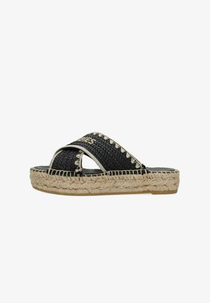 Mule espadrille tissée noire avec une semelle en jute tressé, présentant un design à lanières croisées et des détails de couture contrastants.