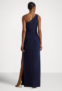 Granatowa wieczorowa sukienka na jedno ramię z wysokim rozcięciem na udzie, wykonana z gładkiej tkaniny. Posiada dopasowany krój i minimalistyczny design.