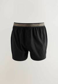 Schwarze Baumwoll-Boxershorts mit einem dekorativen elastischen Bund in Goldmuster und einem Knopfverschluss, mit einer glatten Textur und entspannter Passform.