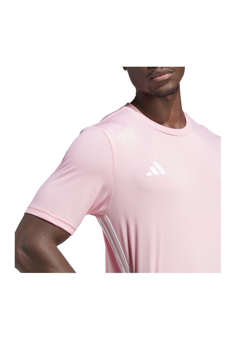 Lichtroze sport T-shirt met korte mouwen, met textuur en gaasdelen en drie witte strepen langs de zijkant. Adidas-logo op de borst.