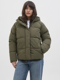 Veste matelassée vert olive avec capuche, dotée d'une fermeture éclair et à pression, de poches latérales et d'une texture matelassée ; portée par-dessus une chemise en flanelle.