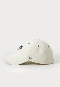 Gorra de pana blanca con un logo bordado en verde, visera curved y seis agujeros de ventilación. Incluye una pequeña etiqueta '47' en el lateral.
