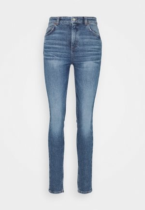 Jean skinny bleu taille haute avec fermeture par bouton et zip, poches avant et arrière, et détails subtilement délavés.