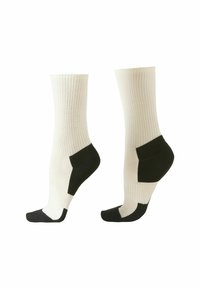 Calcetines de algodón con textura acanalada, de color blanco sucio y detalles negros en la puntera y el talón. Largo hasta medio pantorrilla, ajuste estándar.