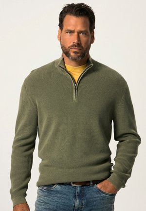Olijfgroene half-zip sweater met een textuurgebreide ontwerp, gedragen over een gele blouse. Heeft lange mouwen en een getailleerde pasvorm.