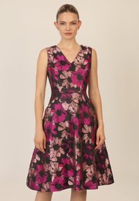 Blumenkleid mit V-Ausschnitt, das große rosa und lila Blumen auf einem schwarzen Hintergrund zeigt. A-Linien-Silhouette mit glatter Textur.