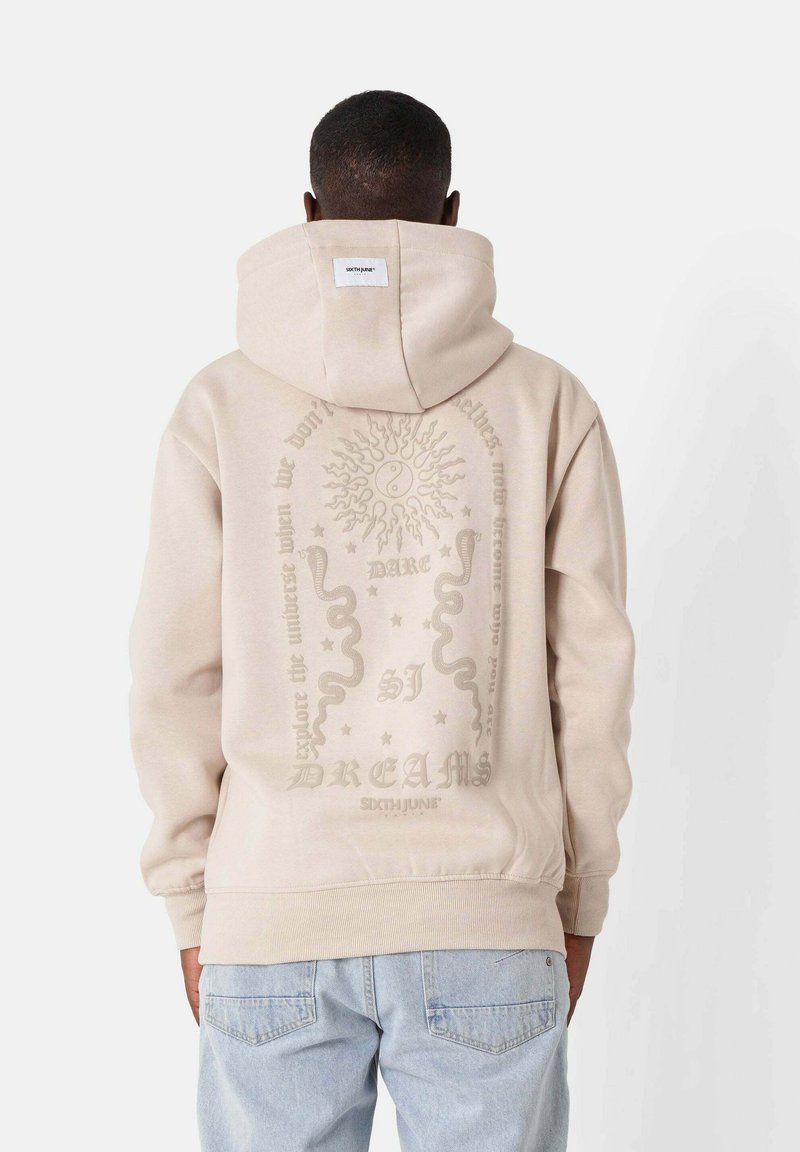 Felpa beige con una grande stampa grafica sul retro, che presenta un sole, serpenti e testo. Realizzata in tessuto morbido con una vestibilità comoda.