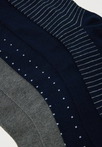 Kolm paari volditud sokke hallis, tumesinises väikeste valgete punktidega ja tumesinises peente valgete triipudega.