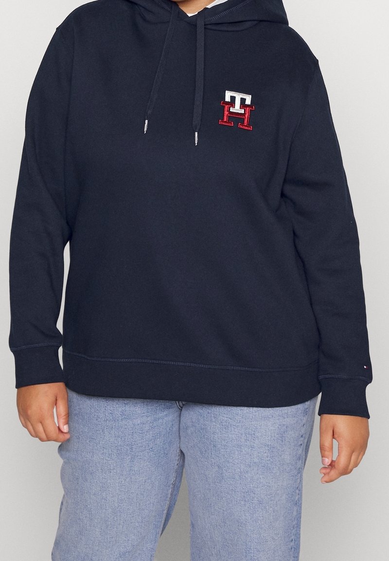 Felpa con cappuccio navy con dettaglio del logo sul petto, realizzata in tessuto morbido, con una vestibilità comoda e tasca frontale a marsupio.