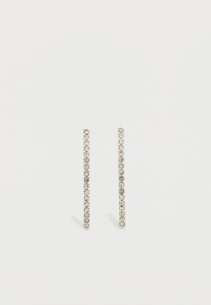 Boucles d'oreilles linéaires en ton argent, ornées de petits cristaux clairs disposés en ligne verticale, soulignant leur design épuré et minimaliste.