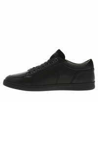 Le sneaker in pelle nera presentano una finitura liscia, punta arrotondata, lacci frontali e accenti testurizzati sui lati. Suola in gomma e profilo basso.