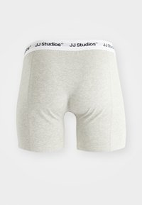 Szürke pamut boxeralsó fehér derékrésszel, melyen fekete "JJ Studios" felirat található. Sima textúra és testhez álló fazon.