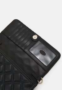 Portafoglio in pelle nera con texture a rombi, multiple tasche per carte, finestra trasparente per ID, chiusura a scatto e un accentuazione in hardware color oro.