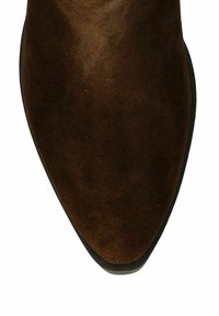 Bottine en suede marron avec un bout pointu et une semelle noire lisse. La texture semble douce avec un léger éclat. Pas de matériel ni de motifs visibles.