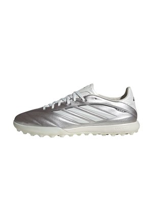 Silver and white Adidas athletic cleat with three stripes on the side, laces, and a textured sole designed for traction.