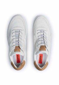 Hellgraue Sportschuhe aus Mesh und Wildleder mit einem hellbraunen Lederakzent, Schnürdesign und rotem Logo auf der Innensohle.